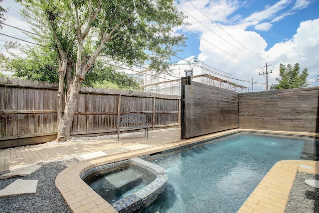 view of swimming pool featuring a fenced backyard and a pool with connected hot tub