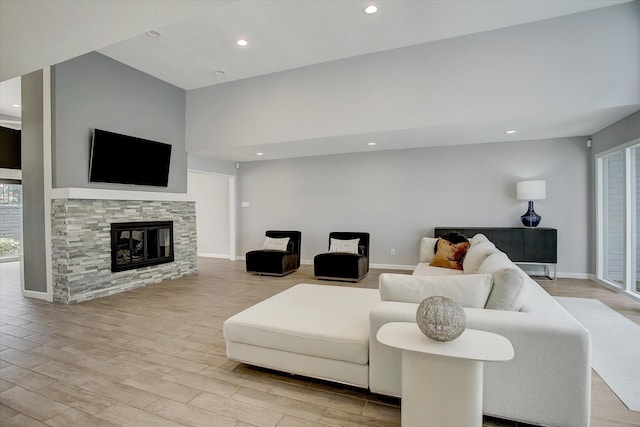 living room featuring recessed lighting, a fireplace, light wood-style flooring, and baseboards