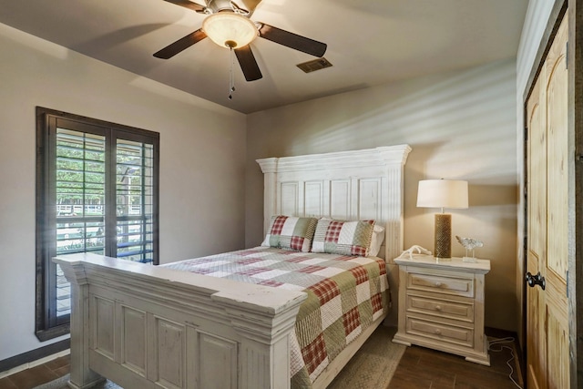 bedroom featuring a ceiling fan, visible vents, and dark wood-style flooring