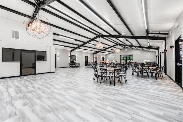 dining area with lofted ceiling, visible vents, and an inviting chandelier