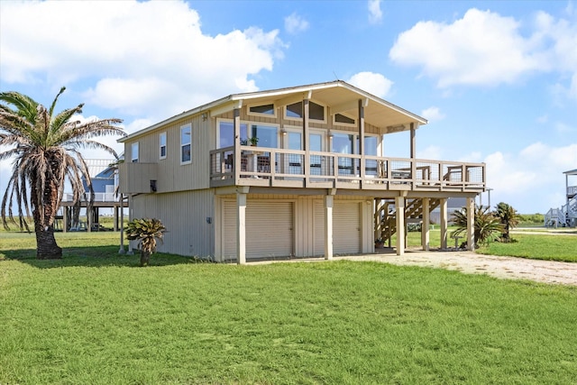 back of house featuring a garage, a yard, and a wooden deck