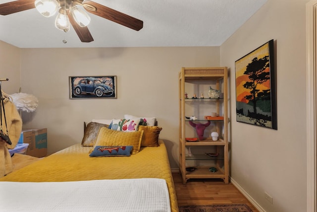 bedroom with baseboards, a ceiling fan, and wood finished floors