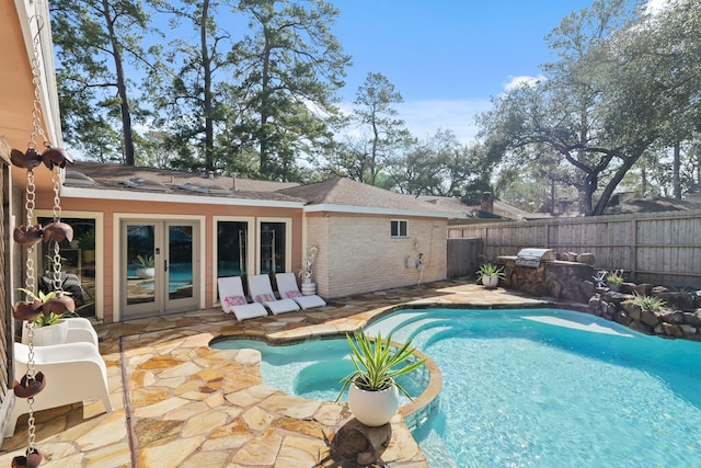 view of pool with a fenced in pool, french doors, a patio area, and fence