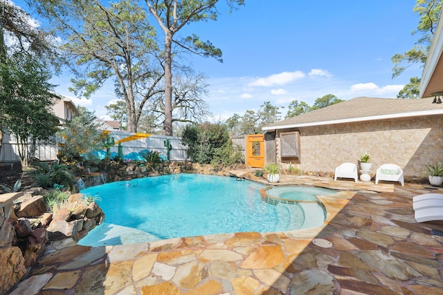 view of pool featuring a patio area, a fenced backyard, and a pool with connected hot tub