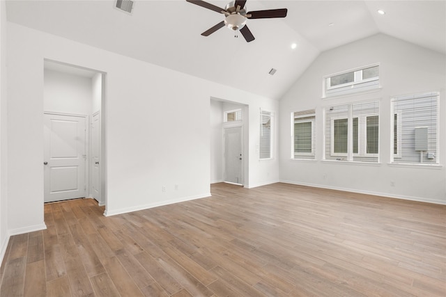 interior space featuring visible vents, baseboards, light wood-style flooring, ceiling fan, and high vaulted ceiling