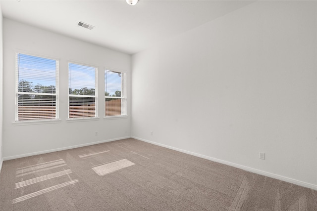 carpeted spare room with baseboards and visible vents