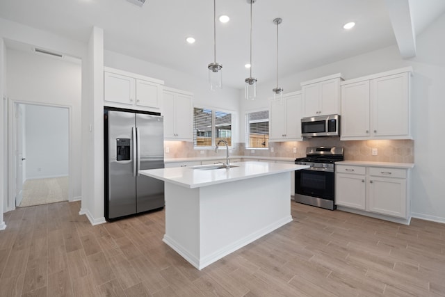 164 W Coralburst Loop, Montgomery, TX 77316 - kitchen featuring stainless steel appliances, a sink, light countertops, light wood-style floors, and white cabinetry