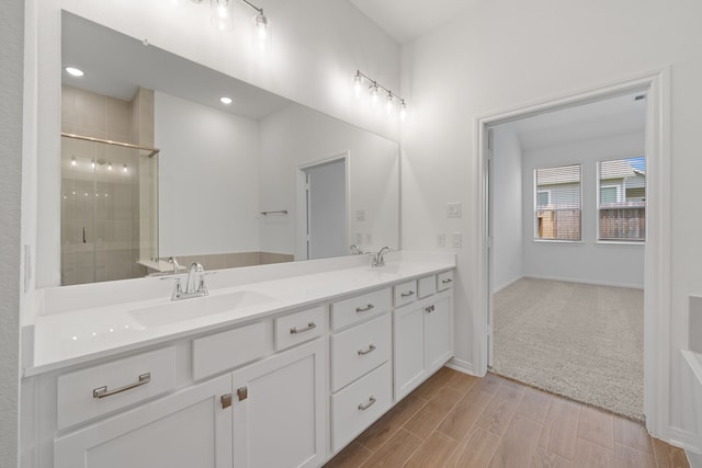 164 W Coralburst Loop, Montgomery, TX 77316 - bathroom with double vanity, a shower stall, wood finished floors, and baseboards