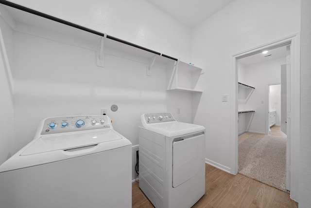 164 W Coralburst Loop, Montgomery, TX 77316 - laundry area with washing machine and dryer and light wood-style flooring