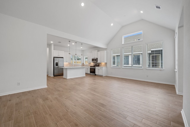 164 W Coralburst Loop, Montgomery, TX 77316 - unfurnished living room with high vaulted ceiling, healthy amount of natural light, recessed lighting, light wood-style floors, and baseboards