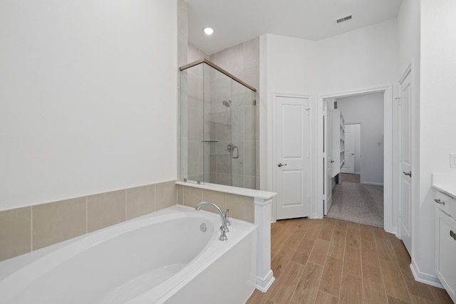 164 W Coralburst Loop, Montgomery, TX 77316 - full bathroom featuring a bath, vanity, a shower stall, wood finished floors, and recessed lighting