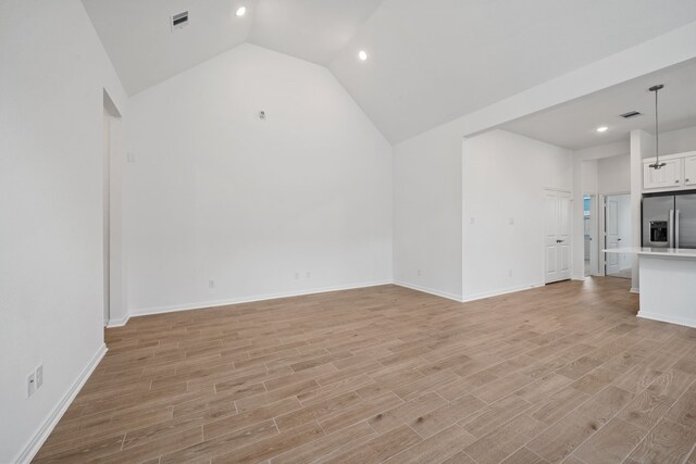 164 W Coralburst Loop, Montgomery, TX 77316 - unfurnished living room featuring vaulted ceiling, light wood-type flooring, recessed lighting, and baseboards