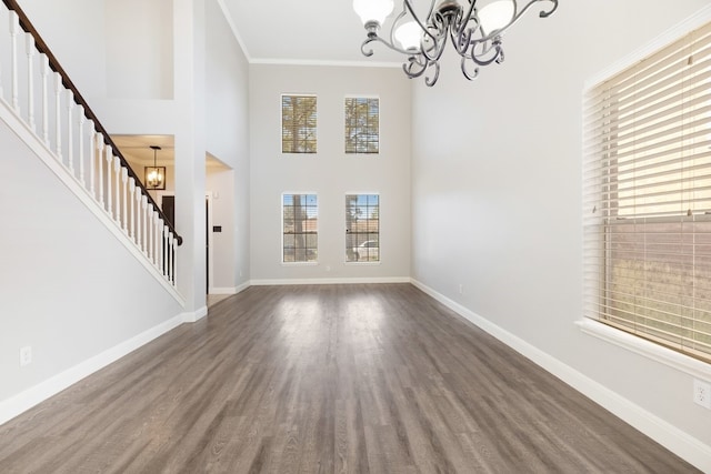 interior space with ornamental molding, a notable chandelier, baseboards, and stairs