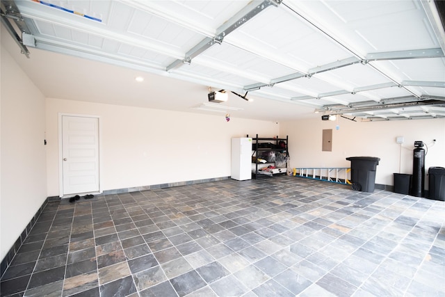 garage with electric panel and a garage door opener