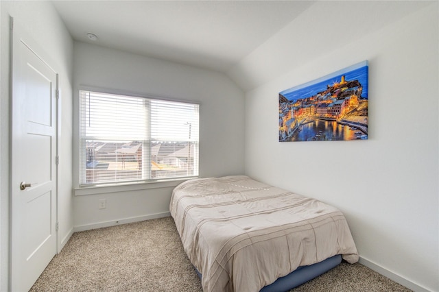 carpeted bedroom with vaulted ceiling and baseboards