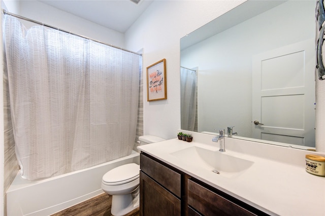 bathroom featuring toilet, shower / bath combo with shower curtain, wood finished floors, and vanity