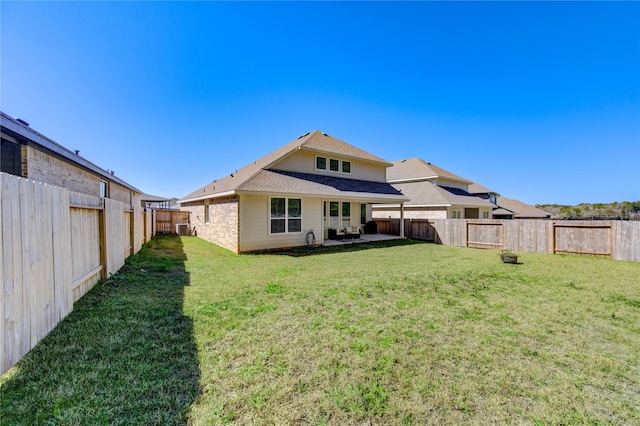 rear view of property with a yard, a patio, and a fenced backyard