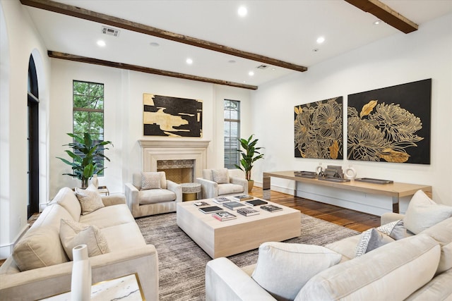 living room with recessed lighting, beam ceiling, a fireplace, and wood finished floors