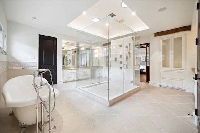 full bath with a freestanding bath, a raised ceiling, vanity, and a shower stall