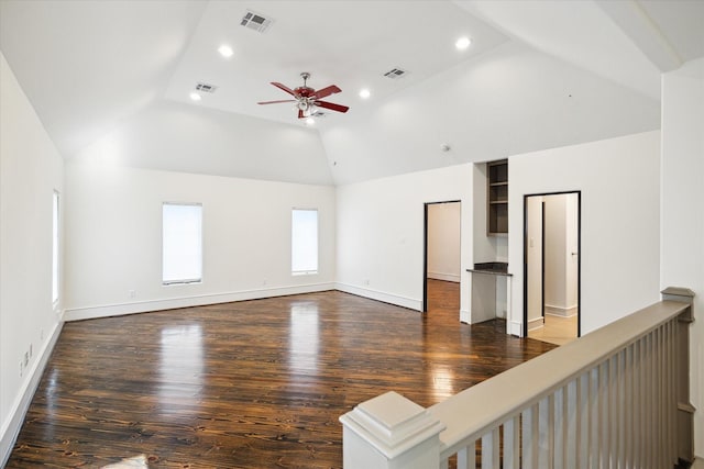 spare room featuring lofted ceiling, ceiling fan, dark wood-type flooring, and visible vents