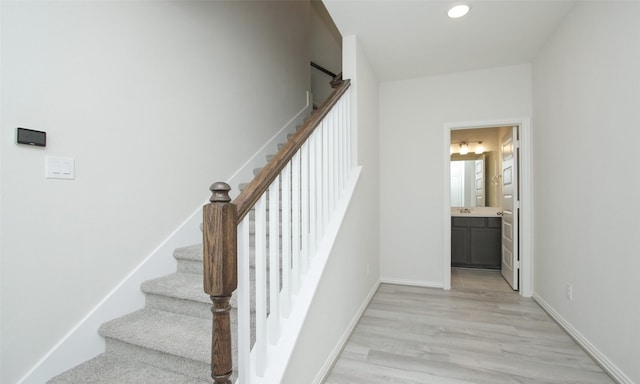 stairway with recessed lighting, wood finished floors, and baseboards