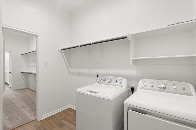 laundry room with laundry area, baseboards, separate washer and dryer, and wood finished floors