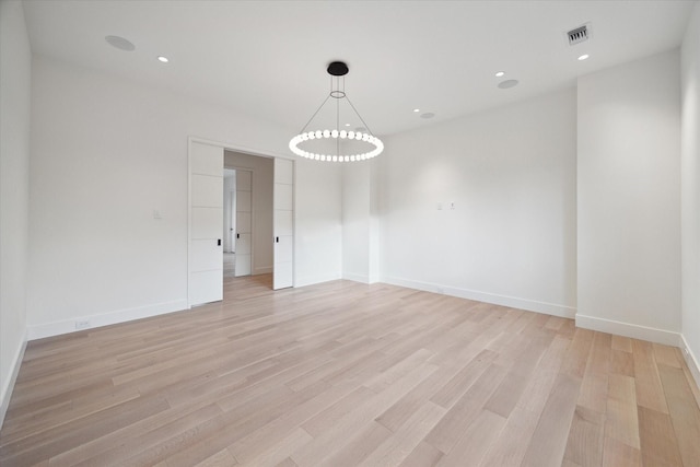 spare room featuring light wood-style flooring, recessed lighting, visible vents, and baseboards