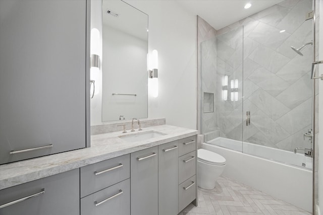 bathroom featuring toilet, recessed lighting, shower / bath combination with glass door, visible vents, and vanity