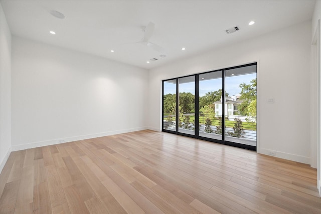 spare room with recessed lighting, light wood-type flooring, visible vents, and baseboards