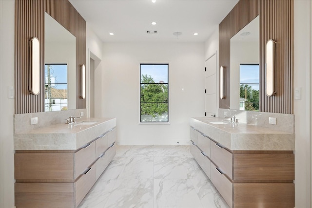 bathroom featuring recessed lighting, marble finish floor, and two vanities