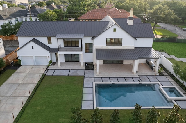 exterior space with fence, stucco siding, metal roof, driveway, and a standing seam roof