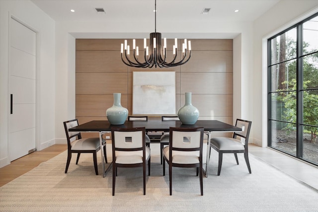 dining room featuring recessed lighting, wood walls, visible vents, light wood finished floors, and an inviting chandelier