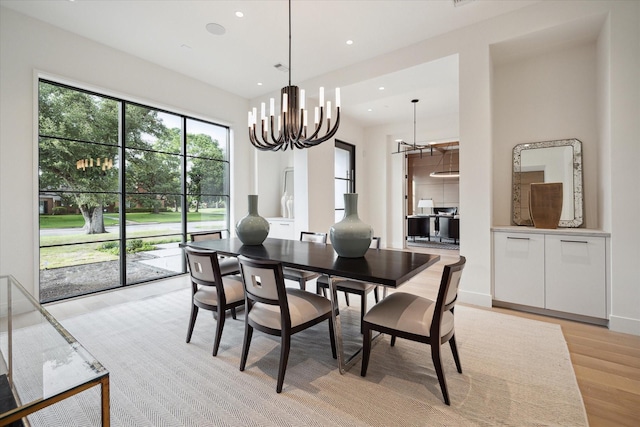 dining area featuring a chandelier, baseboards, light wood-style flooring, and recessed lighting