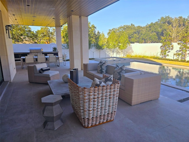 view of patio / terrace featuring a fenced backyard, an outdoor kitchen, a grill, and an outdoor living space