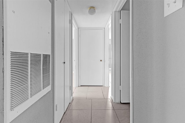 corridor featuring light tile patterned floors and a heating unit