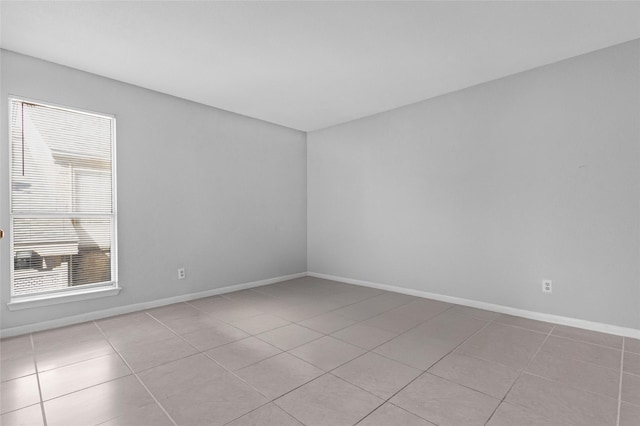 empty room with light tile patterned flooring and baseboards