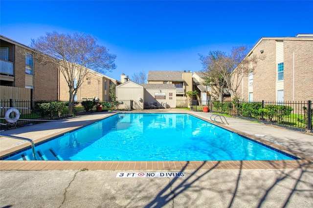 community pool with a residential view, fence, and a patio