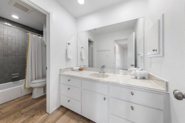 53 La Costa Dr, Montgomery, TX 77356 - bathroom featuring toilet, wood finished floors, vanity, visible vents, and shower / bathtub combination with curtain