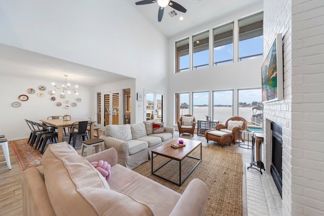 53 La Costa Dr, Montgomery, TX 77356 - living room with ceiling fan with notable chandelier, a fireplace, a water view, visible vents, and light wood finished floors