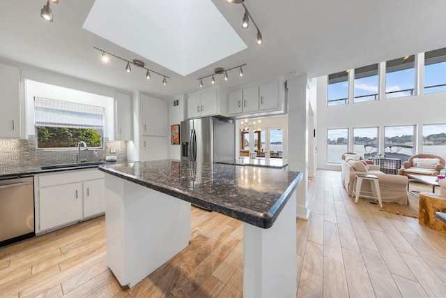 53 La Costa Dr, Montgomery, TX 77356 - kitchen with a center island, stainless steel appliances, backsplash, light wood-style flooring, and a sink