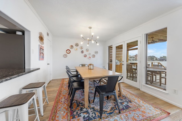 53 La Costa Dr, Montgomery, TX 77356 - dining area featuring light wood-style floors, a chandelier, crown molding, and a textured ceiling