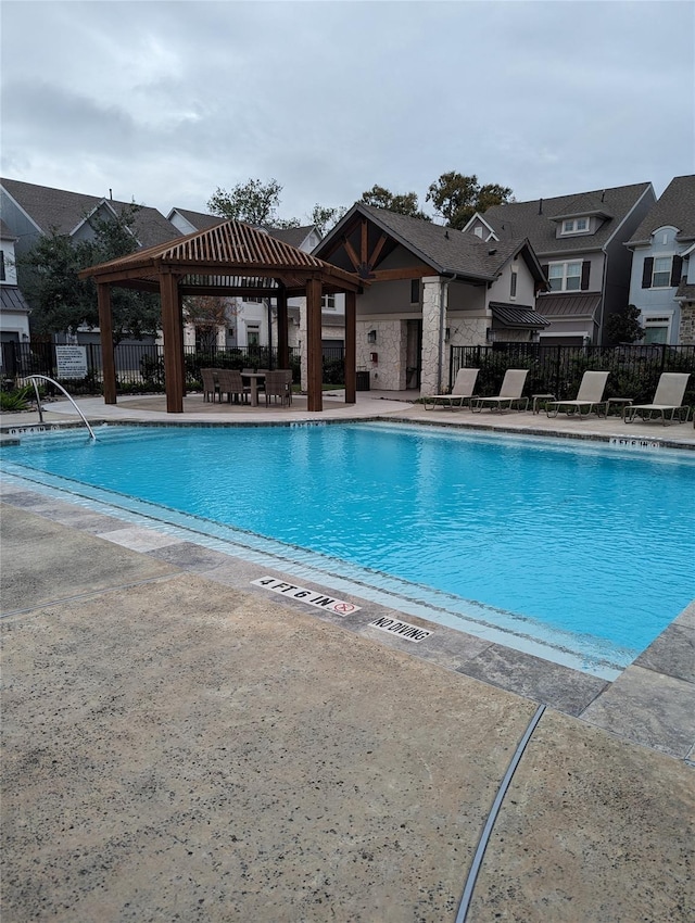 community pool featuring fence, a gazebo, and a patio