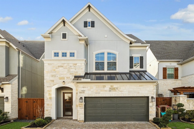 view of front of property featuring metal roof, a garage, decorative driveway, stucco siding, and a standing seam roof