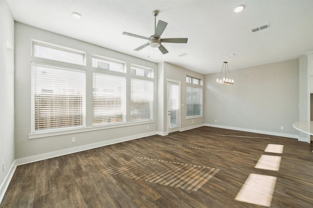 unfurnished living room with visible vents, dark wood finished floors, baseboards, and ceiling fan with notable chandelier