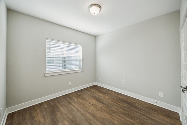 unfurnished room featuring dark wood-style floors and baseboards