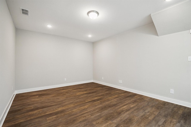 empty room with recessed lighting, visible vents, dark wood finished floors, and baseboards