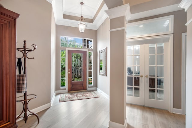 foyer featuring ornamental molding, french doors, light wood-style floors, and baseboards