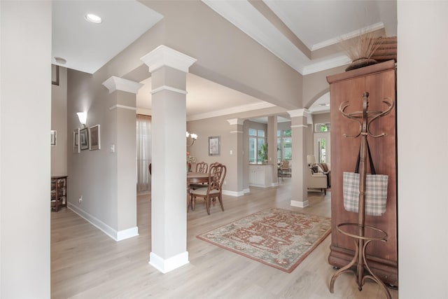 foyer entrance featuring light wood-style floors, decorative columns, ornamental molding, and baseboards