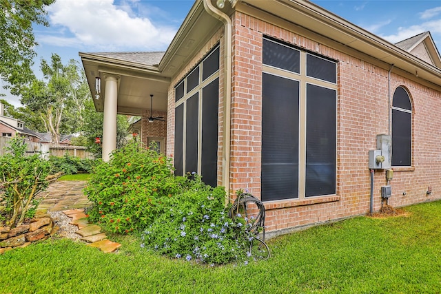 view of side of property with brick siding and a yard