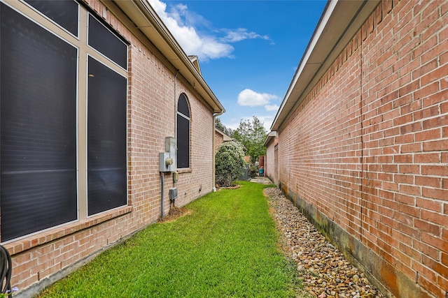 view of side of home featuring a yard and brick siding